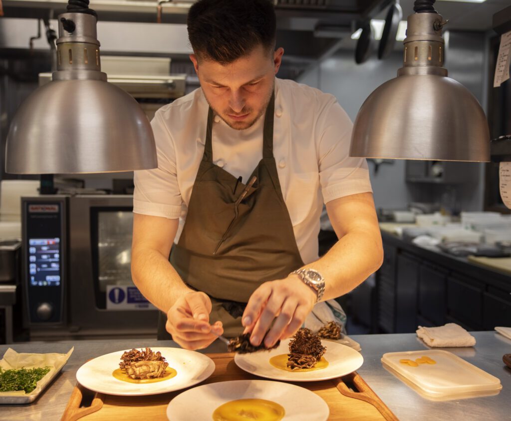 Chef is plating food at Murano